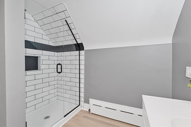 7032 Reynolds St, Point Breeze, PA 15208 - full bathroom featuring a baseboard heating unit, a stall shower, and wood finished floors