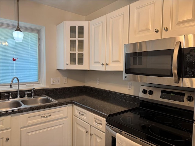 1523 Timothy Dr, Derry Twp, PA 15650 - kitchen featuring stainless steel appliances, white cabinets, dark countertops, glass insert cabinets, and pendant lighting