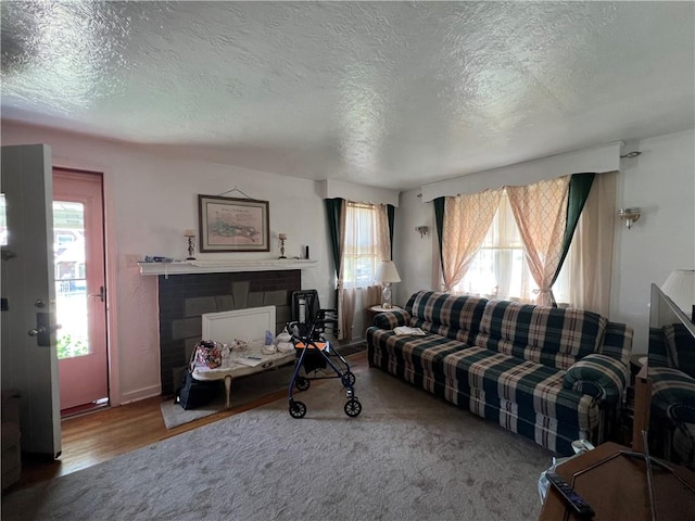 1104 Jefferson St, Mckeesport, PA 15132 - living area featuring a textured ceiling, a brick fireplace, and wood finished floors