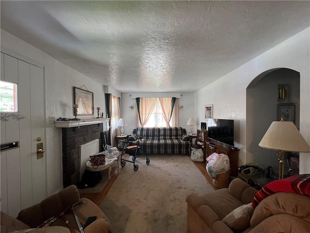 1104 Jefferson St, Mckeesport, PA 15132 - living area featuring a fireplace with raised hearth, arched walkways, and a textured ceiling