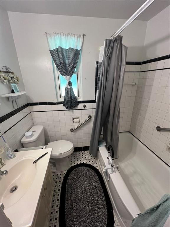 1104 Jefferson St, Mckeesport, PA 15132 - bathroom featuring tile walls, shower / bath combo, wainscoting, vanity, and tile patterned flooring