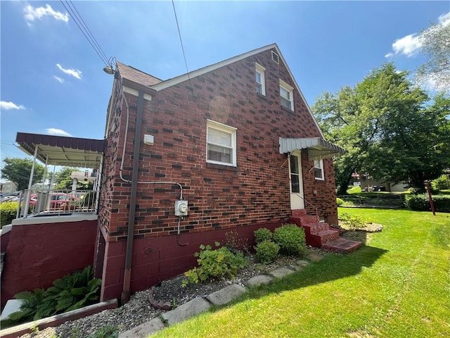 1104 Jefferson St, Mckeesport, PA 15132 - view of home's exterior with brick siding, a lawn, and entry steps