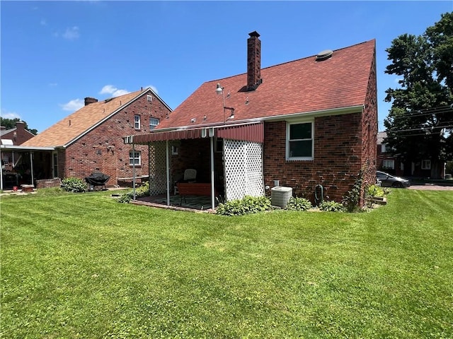 1104 Jefferson St, Mckeesport, PA 15132 - rear view of house with a yard, a chimney, and brick siding