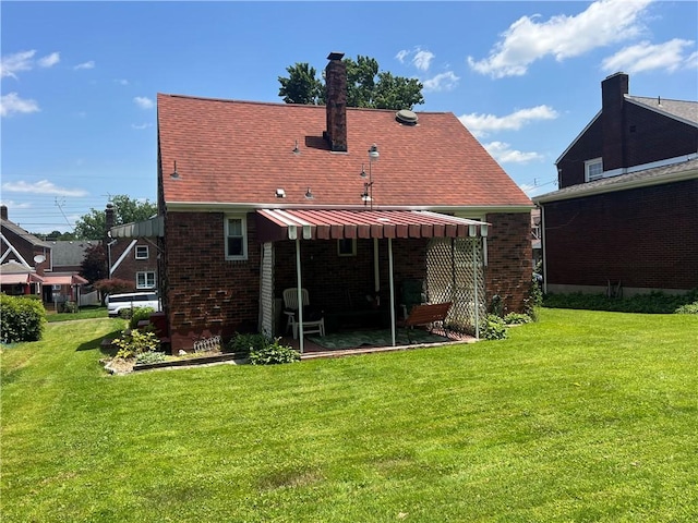 1104 Jefferson St, Mckeesport, PA 15132 - back of property with a yard, brick siding, and a patio area