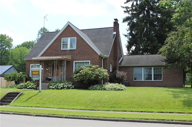 539 Milliken Ave, Sharpsville, PA 16150 - view of front of house featuring brick siding, a front yard, a chimney, and a shingled roof