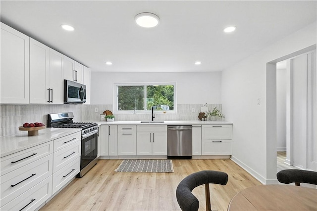 1233 High St, Spring Garden, PA 15212 - kitchen featuring stainless steel appliances, light countertops, tasteful backsplash, white cabinets, and light wood-type flooring