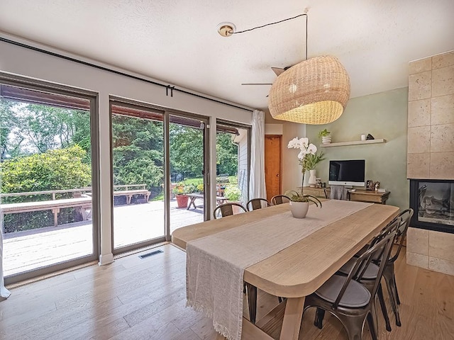 554 Rolling Green Dr, Bethel Park, PA 15102 - dining room featuring plenty of natural light, wood finished floors, a tiled fireplace, and a ceiling fan