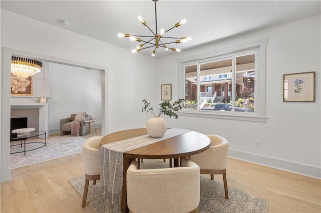 3246 Piedmont Ave, Dormont, PA 15216 - dining area featuring a chandelier, light wood-style flooring, and a fireplace