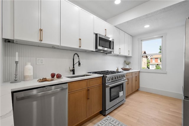 3246 Piedmont Ave, Dormont, PA 15216 - kitchen with stainless steel appliances, light countertops, white cabinets, light wood-style floors, and recessed lighting