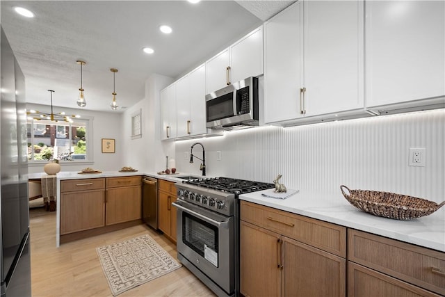 3246 Piedmont Ave, Dormont, PA 15216 - kitchen featuring stainless steel appliances, light wood-style flooring, white cabinets, pendant lighting, and a chandelier