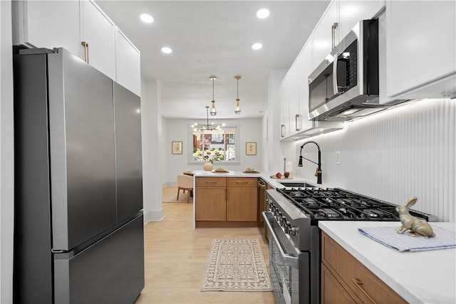 3246 Piedmont Ave, Dormont, PA 15216 - kitchen with appliances with stainless steel finishes, light countertops, light wood-type flooring, a peninsula, and recessed lighting