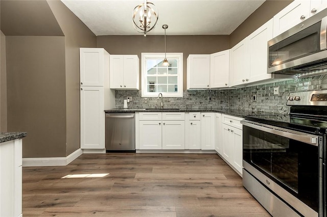 413 Spring St, Grove City Boro, PA 16127 - kitchen with appliances with stainless steel finishes, tasteful backsplash, white cabinetry, and hanging light fixtures