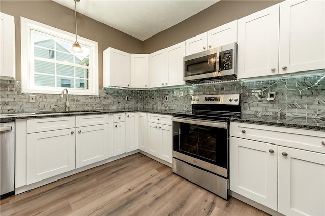 413 Spring St, Grove City Boro, PA 16127 - kitchen with stainless steel appliances, white cabinets, backsplash, and dark stone counters