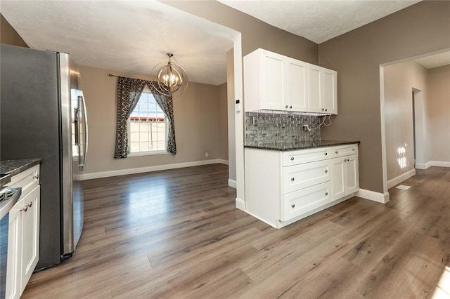 413 Spring St, Grove City Boro, PA 16127 - kitchen featuring a chandelier, wood finished floors, white cabinets, and tasteful backsplash