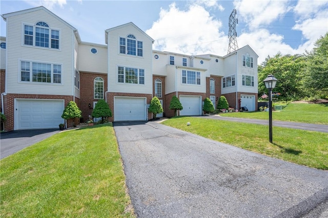318 Links Ct, Salem Twp Wml, PA 15626 - townhome / multi-family property featuring brick siding, asphalt driveway, an attached garage, and a front yard