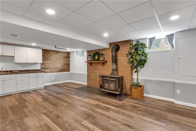 2161/2 Robin Hood Dr, Irwin, PA 15642 - unfurnished living room featuring a wood stove, wood finished floors, a drop ceiling, wood walls, and recessed lighting