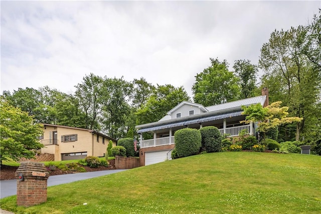 2161/2 Robin Hood Dr, Irwin, PA 15642 - view of front of property with a front lawn, a garage, a chimney, a metal roof, and view of scattered trees