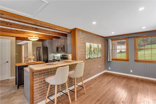 2161/2 Robin Hood Dr, Irwin, PA 15642 - kitchen featuring appliances with stainless steel finishes, light countertops, a breakfast bar area, light wood-style floors, and a peninsula