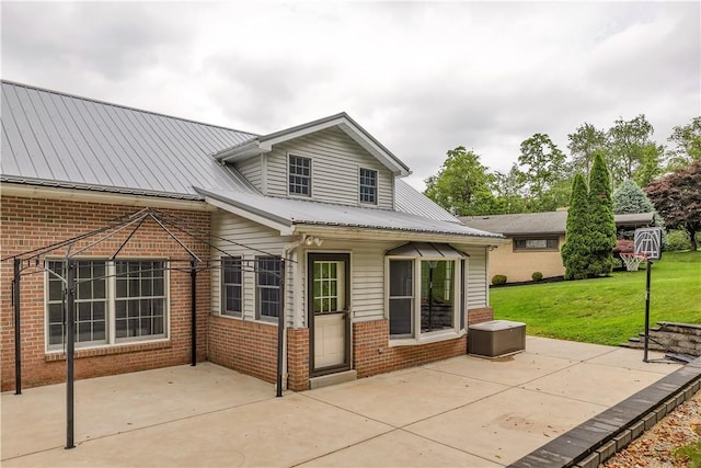 2161/2 Robin Hood Dr, Irwin, PA 15642 - rear view of house with a patio area, brick siding, a lawn, and a metal roof