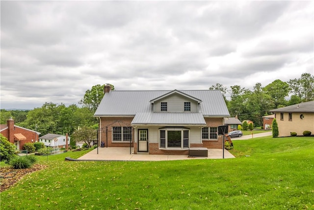 2161/2 Robin Hood Dr, Irwin, PA 15642 - rear view of property featuring brick siding, a patio area, a yard, and a metal roof