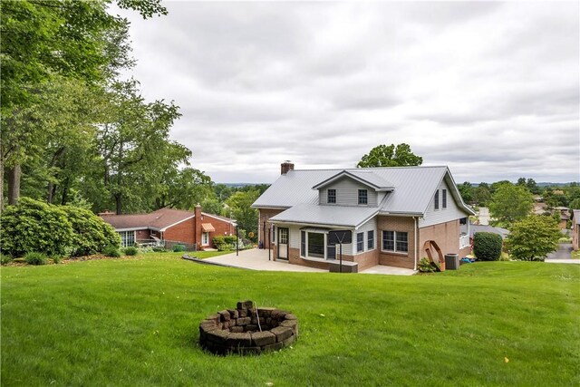 2161/2 Robin Hood Dr, Irwin, PA 15642 - back of house featuring brick siding, a patio area, a lawn, and an outdoor fire pit
