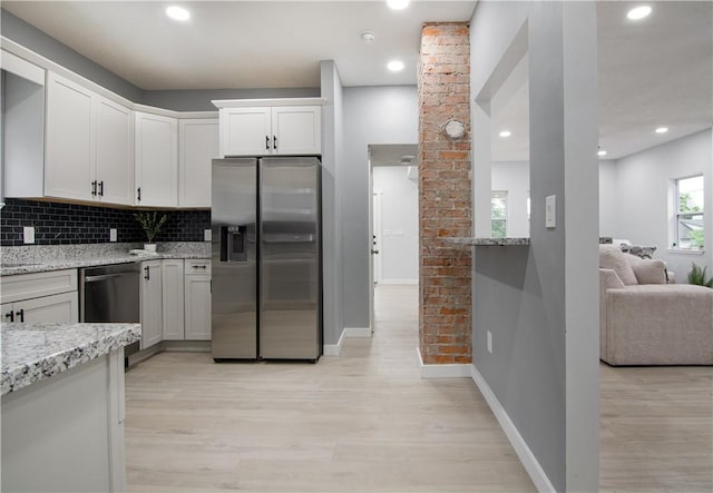 226 Main Street Ext, Callery Boro, PA 16024 - kitchen featuring appliances with stainless steel finishes, light wood-style flooring, light stone counters, decorative backsplash, and white cabinetry