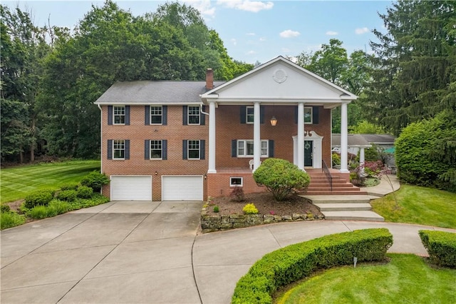 2590 Wildwood Rd, Hampton, PA 15101 - neoclassical / greek revival house with concrete driveway, a garage, brick siding, a chimney, and a front lawn