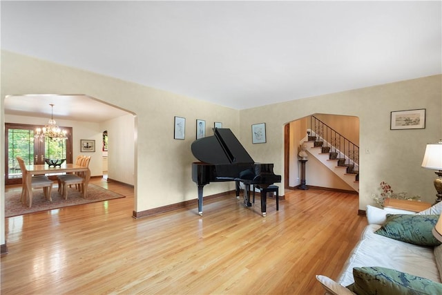 2590 Wildwood Rd, Hampton, PA 15101 - living room with arched walkways, light wood-type flooring, a chandelier, and stairs