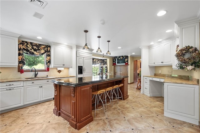 2590 Wildwood Rd, Hampton, PA 15101 - kitchen featuring a breakfast bar, a kitchen island, recessed lighting, white cabinets, and backsplash
