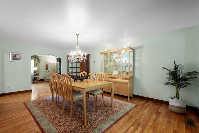 2590 Wildwood Rd, Hampton, PA 15101 - dining area featuring arched walkways, a chandelier, and light wood-style flooring