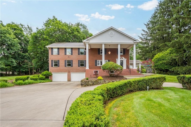 2590 Wildwood Rd, Hampton, PA 15101 - neoclassical / greek revival house with an attached garage, concrete driveway, brick siding, a front lawn, and a porch