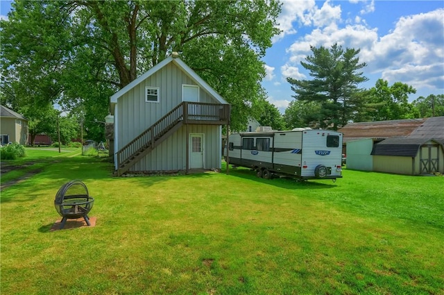 516 5th St, Darlngtn Twp, PA 16115 - back of property with board and batten siding, a storage shed, a yard, stairway, and an outdoor fire pit