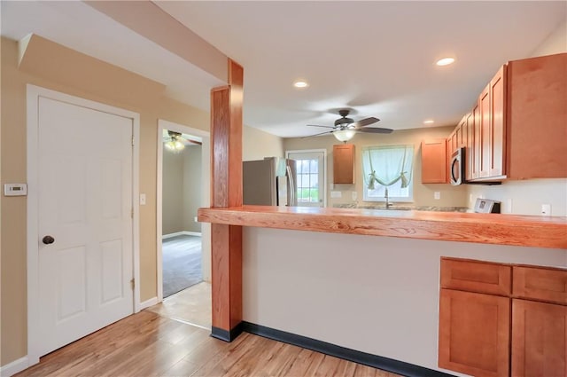516 5th St, Darlngtn Twp, PA 16115 - kitchen featuring stainless steel appliances, light countertops, ceiling fan, light wood finished floors, and a peninsula