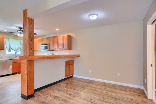 516 5th St, Darlngtn Twp, PA 16115 - kitchen featuring stainless steel appliances, light wood finished floors, light countertops, ceiling fan, and a peninsula