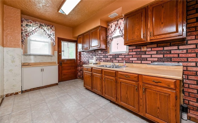 4123 Stanley St, Greenfield, PA 15207 - kitchen with light countertops, brown cabinetry, healthy amount of natural light, and a textured ceiling