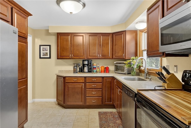 1171 La Salle Rd, Monroeville, PA 15146 - kitchen featuring appliances with stainless steel finishes, light countertops, light tile patterned flooring, and brown cabinetry