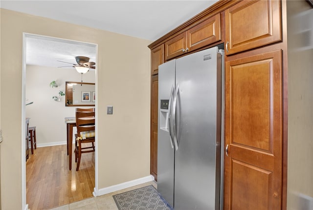 1171 La Salle Rd, Monroeville, PA 15146 - kitchen with stainless steel fridge, ceiling fan, brown cabinetry, and light wood finished floors