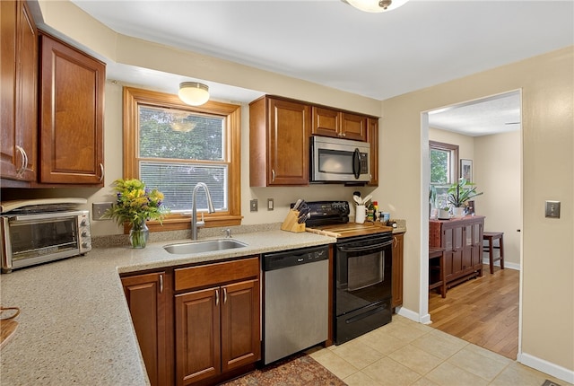 1171 La Salle Rd, Monroeville, PA 15146 - kitchen featuring stainless steel appliances, light countertops, brown cabinets, and light tile patterned floors