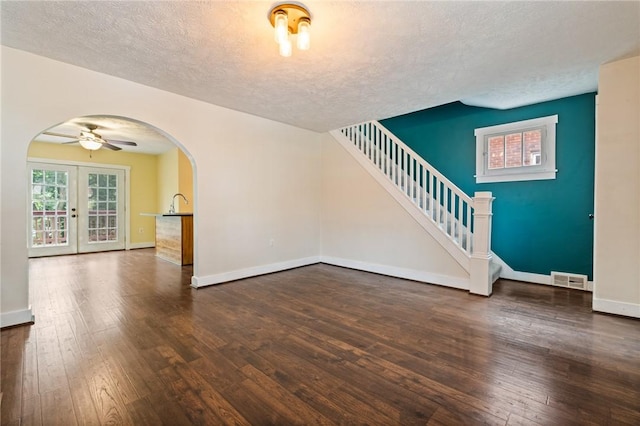 2072 Dartmore St, Overbrook, PA 15210 - unfurnished living room featuring arched walkways, a textured ceiling, hardwood / wood-style flooring, stairs, and a ceiling fan