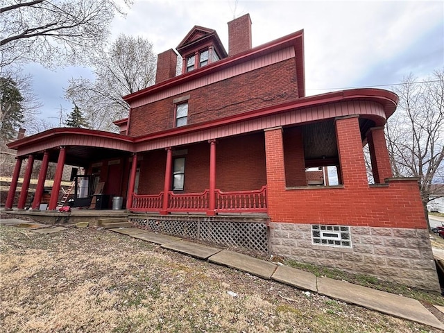 26 Carrick Ave, Carrick, PA 15210 - view of home's exterior with brick siding, covered porch, and a chimney