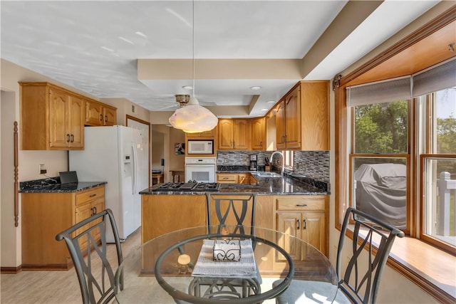 116 Rizzi Dr, Penn Twp Wml, PA 15642 - kitchen with white appliances, tasteful backsplash, brown cabinets, dark stone countertops, and ceiling fan