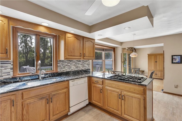 116 Rizzi Dr, Penn Twp Wml, PA 15642 - kitchen featuring white dishwasher, stovetop with downdraft, a peninsula, backsplash, and dark stone counters