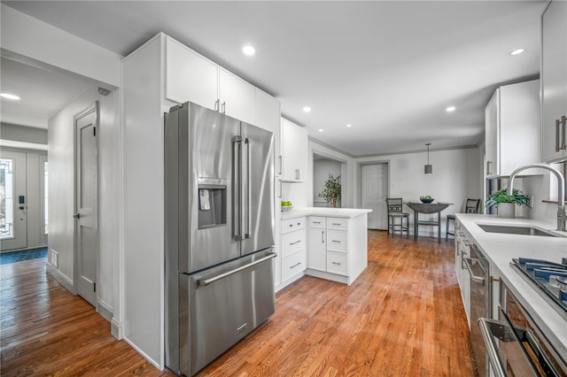 1202 Oakridge Rd, South Fayette, PA 15057 - kitchen with high quality fridge, a peninsula, light countertops, light wood-style flooring, and white cabinetry