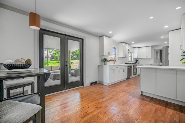 1202 Oakridge Rd, South Fayette, PA 15057 - kitchen with french doors, light countertops, white cabinetry, ornamental molding, and light wood-style floors
