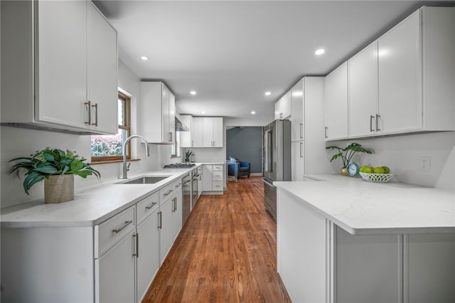 1202 Oakridge Rd, South Fayette, PA 15057 - kitchen with appliances with stainless steel finishes, a peninsula, dark wood finished floors, white cabinetry, and recessed lighting