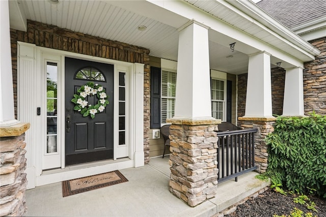322 Dirkshire Ct, Adams Twp, PA 16046 - view of exterior entry with a porch, stone siding, and roof with shingles