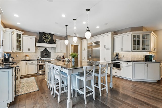 322 Dirkshire Ct, Adams Twp, PA 16046 - kitchen featuring custom range hood, high end appliances, a center island, backsplash, and dark wood finished floors