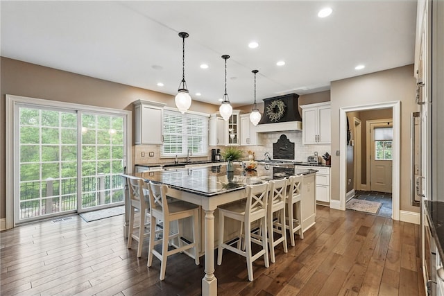 322 Dirkshire Ct, Adams Twp, PA 16046 - kitchen with custom range hood, dark wood-style flooring, a kitchen bar, recessed lighting, and decorative backsplash