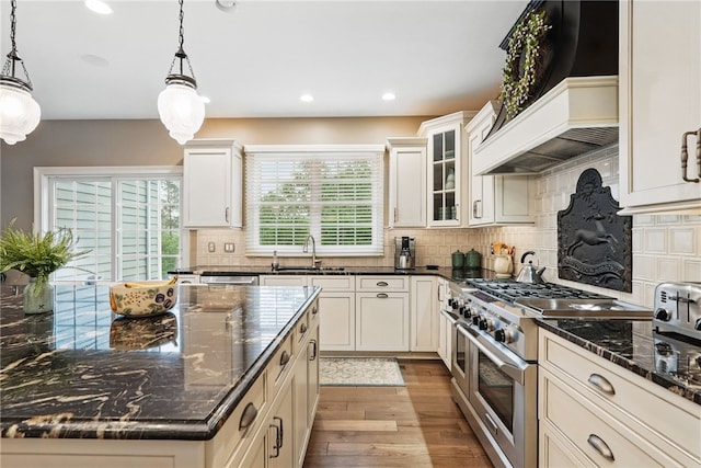 322 Dirkshire Ct, Adams Twp, PA 16046 - kitchen with range with two ovens, custom range hood, light wood-type flooring, backsplash, and pendant lighting