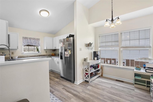 196 Oakbrook Cir, Banksville/Westwood, PA 15220 - kitchen with stainless steel fridge with ice dispenser, light wood-style flooring, vaulted ceiling, white cabinets, and pendant lighting